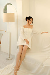 Silk mini dress with ruched bodice and puff sleeves featuring delicate bow-tie accents